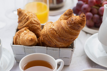 French breakfast, hot beverage and croissants, fruits, orange juice. Good morning concept background.