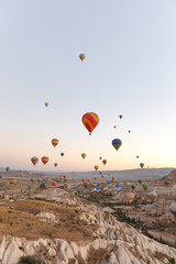 Hot air balloons flying over rock landscape at Cappadocia