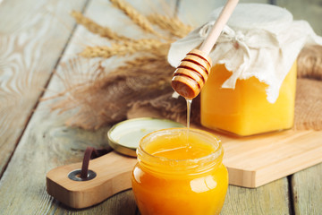 Honey background. Sweet honey in glass jar on wooden background.