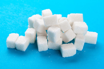 White sugar cubes on a bright blue background