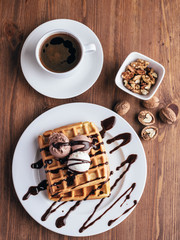 Belgian waffles with ice cream. Chocolate and nuts. wooden table. Rustik