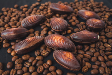  chocolate figures and coffee beans. chocolate and coffee. chocolate shells on a black background