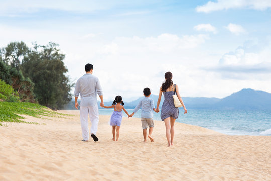Happy young family walking on beach