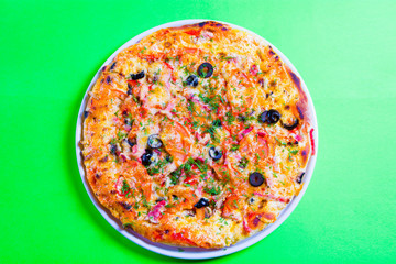 hot tasty fresh pizza on a plate close-up. green background
