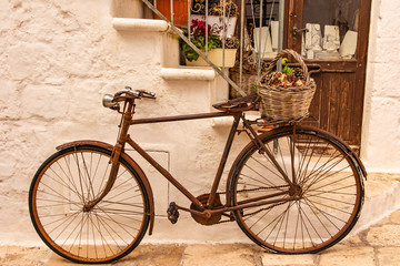 Fototapeta na wymiar Italy, Ostuni, old bicycle leaning against the wall, for tourists.