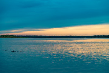 Fototapeta premium summer landscape on the banks of the green river at sunset, Russia