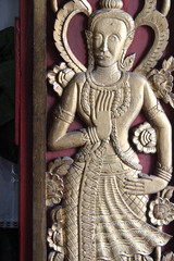 bas-relief on a shutter in a buddhist temple (Wat Phra That Haripunchai) in Lamphun (Thailand)