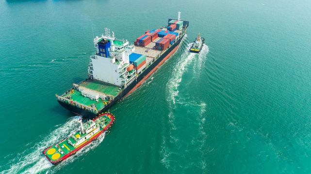 Aerial view tug boat drag container ship to sea port for logistics, import export, shipping or transportation.