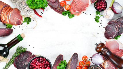 Set of smoked and dried meat Ham, jerky, salted biltong meat, spices and herbs. Top view. Free space for your text.