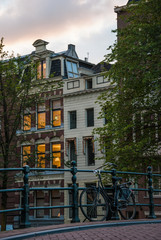 Bike leaned on railings of bridge with houses in the background