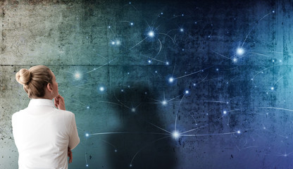 blonde woman looking at projection of network structure with glowing nodes on rough concrete wall