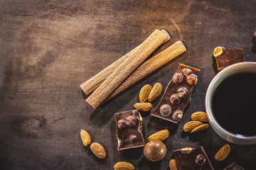black coffee, chocolate, almonds, cookies. on a dark wooden background.