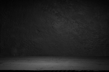 cement floor in dark room with spot light. black background.