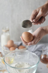 Baker hands using a spoon to crack an egg. Concept of Cooking ingredients and method in kitchen, Dessert recipes and homemade.