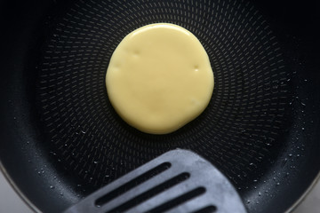 Pancakes onto the pan. Concept of Cooking ingredients and method on white marble background, Dessert recipes and homemade.