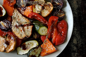 Plate with baked vegetables with sesame. Stylish vegan dinner. Garnish of grilled vegetables.