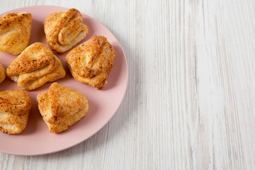 Homemade cottage cheese biscuits on a pink plate over white wooden background, low angle view. Copy space.