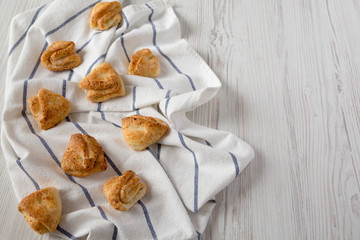 Home-baked cottage cheese biscuits on cloth over white wooden background, side view. Copy space.