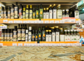 Grocery store. Shelves with olive, rapeseed and sunflower oil. Defocused, blurred image.