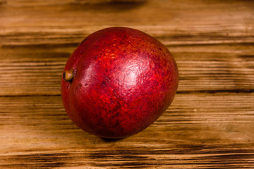 Whole red mango fruit on a wooden table