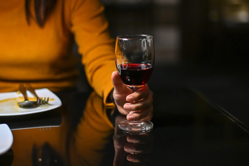 Woman holding a glass of red wine with vintage tone.