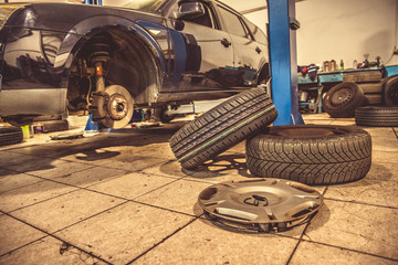Replacing winter tires on summer tires in a professional garage with the help of professional tools. car on a hydraulic jack