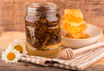 Fresh honeycombs in bowl on wooden background. closeup