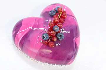 Mousse cake with mirror glaze decorated with blueberry and red currant