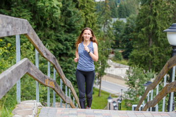 Young running woman ascending stairs in the morning
