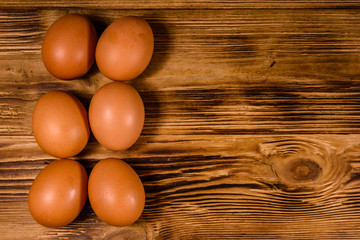 Pile of the hen eggs on wooden table. Top view