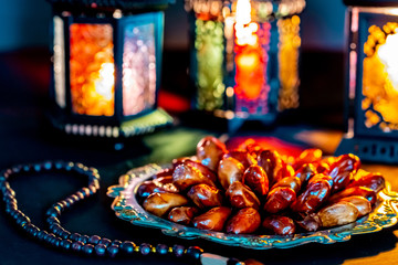 The Muslim feast of the holy month of Ramadan Kareem with dates on a tray on a dark background....