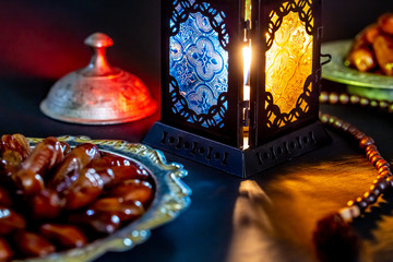 The Muslim feast of the holy month of Ramadan Kareem with dates on a tray on a dark background....