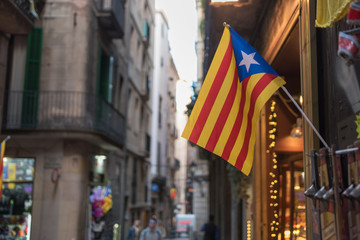 Fototapeta na wymiar Flag of Catalonia on background of the street.
