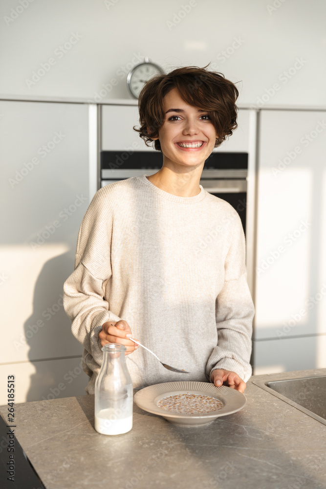 Wall mural Vertical image of Smiling brunette woman having dinner