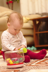 a small child is sitting on the floor in the room and playing with ear sticks