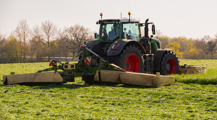 Landwirtschaftlicher Trecker mäht Gras für Heuernte