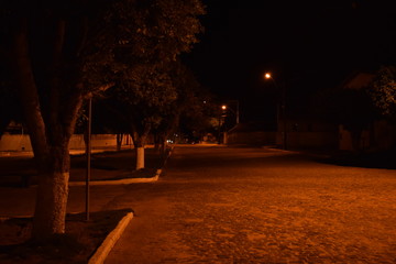 Cena noturna de praça com iluminação âmbar
