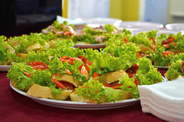 Sandwiches with red fish and lettuce on white bread during the buffet table with napkins