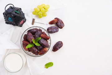 Ramadan food and drinks concept. Ramadan Lantern with Milk, dates fruit, grape and Mint leaves on a white wooden table background. Top view, Flat lay.