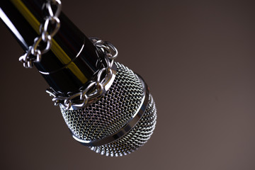 Microphone with a chain, depicting the idea of freedom of the press or freedom of expression on...