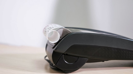 man with card is using the terminal for payment, terminal issues a check, side view.