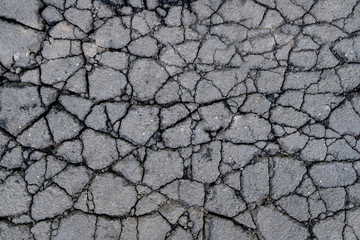 Old worn and cracked asphalt with cracks. Cracked asphalt background