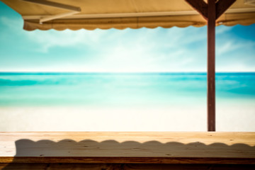 Desk of free space and summer beach with umberlla 