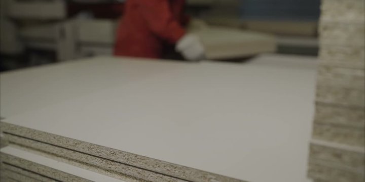 Dvp production. Worker with boards in a factory. The young master folds the board.