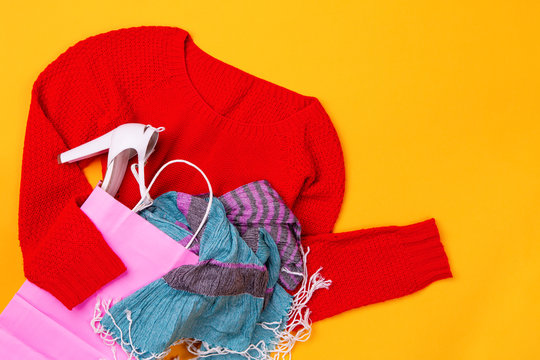 Pink shopping bag with red swether, stylish shoes, scarf, red belt and gloves and glasses