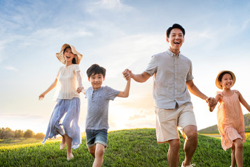 Happy young family running on meadow