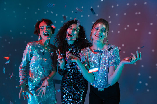 Happy Three beauty women wearing in shiny clothes