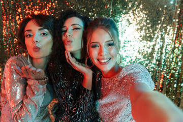 Lovely Three beauty women wearing in shiny clothes
