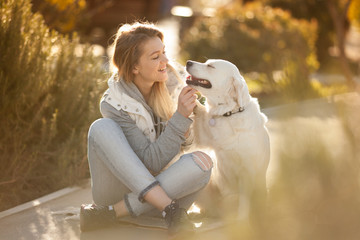 beautiful girl with a dog breed Golden Retriever best friends on a walk looking at each other, the dog gives a paw