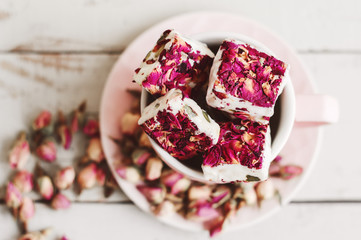 Lebanese sweets with edible flower petals. Nougat. Turkish delight with hibiscus - obrazy, fototapety, plakaty